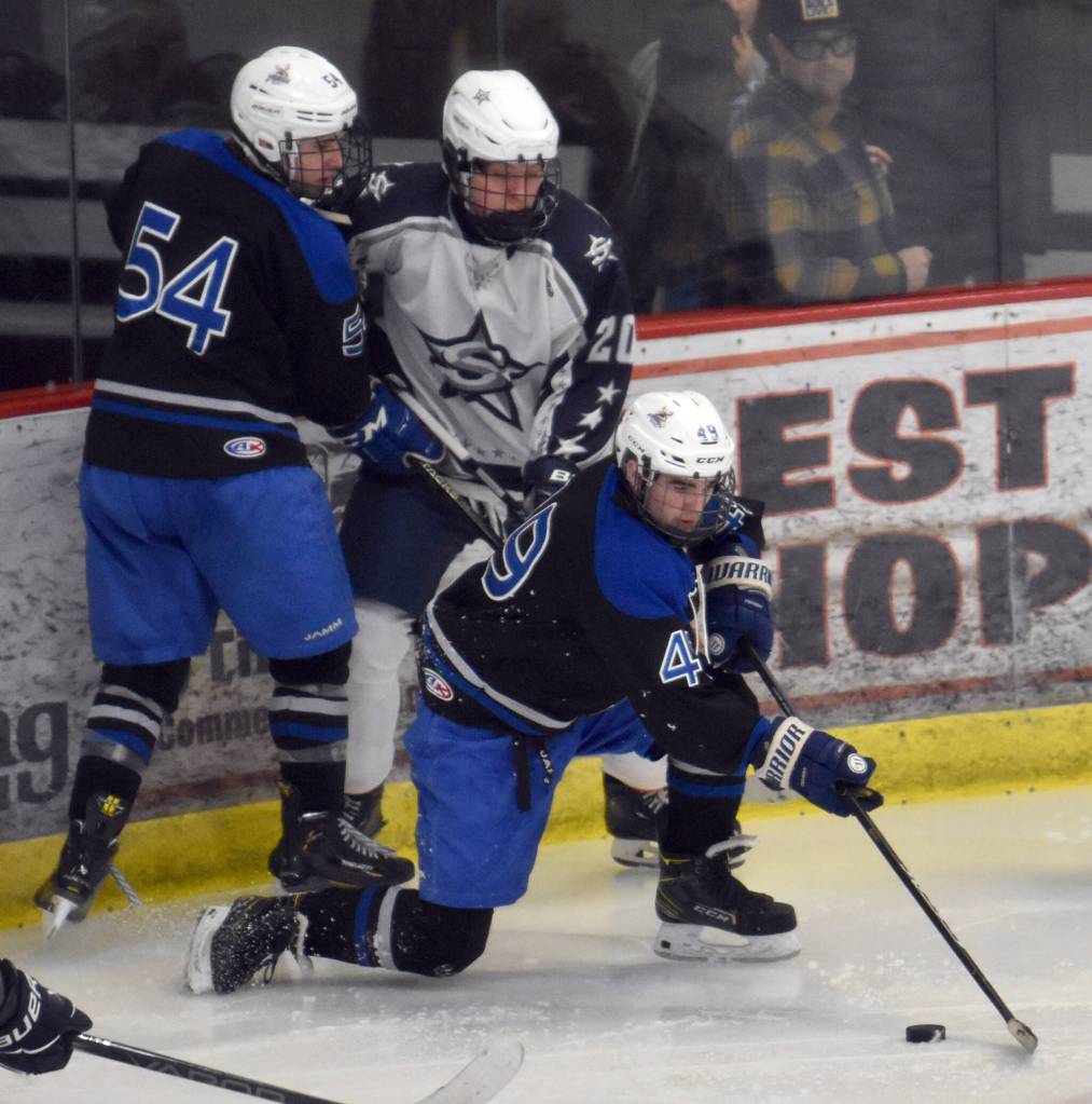 Palmers Nicholas McQuillin controls the puck in front of Palmers Peyton Neumann and Soldotnas Peter Perez on Friday, Dec. 6, 2024, at the Soldotna Regional Sports Complex in Soldotna, Alaska. (Photo by Jeff Helminiak/Peninsula Clarion)