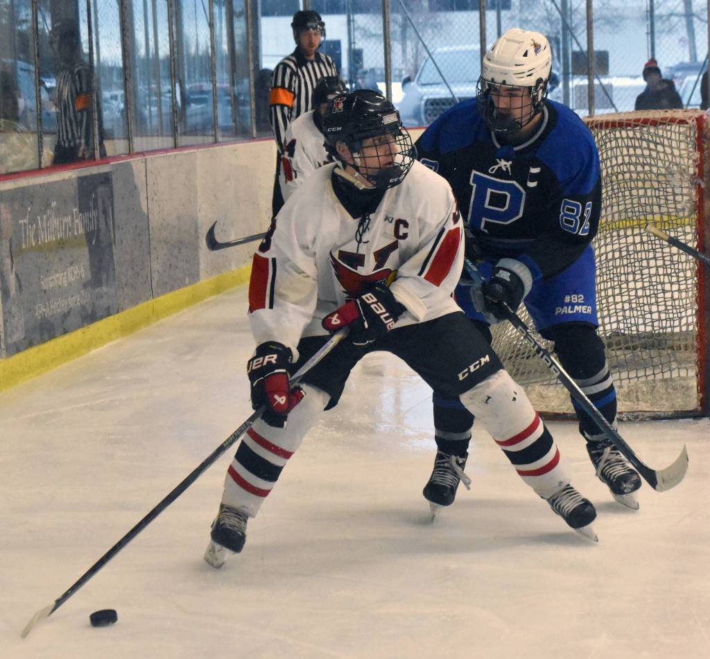 Kenai Centrals Logan Mese holds the puck from Palmers Zidane Dietz on Saturday, Dec. 7, 2024, at the Kenai Multi-Purpose Facility in Kenai, Alaska. (Photo by Jeff Helminiak/Peninsula Clarion)