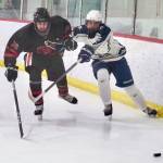 Juneau-Douglas senior Ike Puustinen (16) works for a puck against Soldotnas Eli Settlemyer (28) during a 4-3 Crimson Bears loss to the visiting Stars at Treadwell Ice Arena in Juneau, Alaska, on Friday, Dec. 13, 2024. (Klas Stolpe / Juneau Empire)