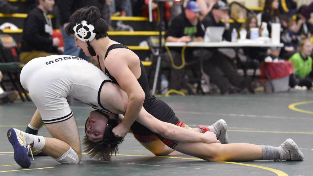 Kenai Centrals Gunnar Stanley wrestles to a victory over Nikiskis Wyatt Maguire in the championship match at 140 pounds at the Kachemak Conference wrestling tournament at Seward High School in Seward, Alaska, on Saturday, Dec. 14, 2024. (Photo by Jeff Helminiak/Peninsula Clarion)