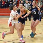 Kenai Centrals Bryleigh Williams drives against Palmers Kaylyn Miller and Jasmine Hephner on Thursday, Dec. 19, 2024, at Kenai Central High School in Kenai, Alaska. (Photo by Jeff Helminiak/Peninsula Clarion)