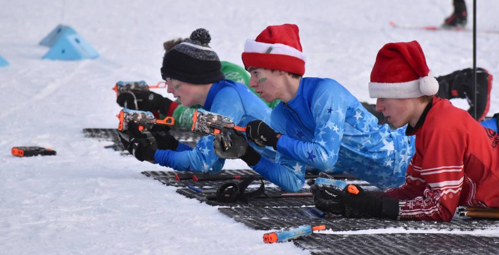 From left to right, Soldotna's Owen Bell, Soldotna's Jacob Ries and Kenai Central's Benjamin Roberts take to the range at the Candy Cane Scramble on Friday, Dec. 20, 2024, at Tsalteshi Trails just outside of Soldotna, Alaska. (Photo by Jeff Helminiak/Peninsula Clarion)