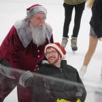 Santa Claus pushes a man across the ice during Skate with Santa at the Soldotna Regional Sports Complex in Soldotna, Alaska, on Saturday, Dec. 21, 2024. (Jake Dye/Peninsula Clarion)