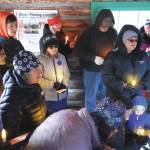 Jake Dye/Peninsula Clarion
A group of people sing Silent Night in the Elwell Fishing Lodge at the Kenai National Wildlife Refuge near Soldotna on Christmas Eve.