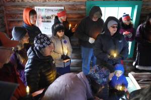 A group of people sing Silent Night in the Elwell Fishing Lodge at the Kenai National Wildlife Refuge near Soldotna, Alaska, on Christmas Eve, Dec. 24, 2024. (Jake Dye/Peninsula Clarion)