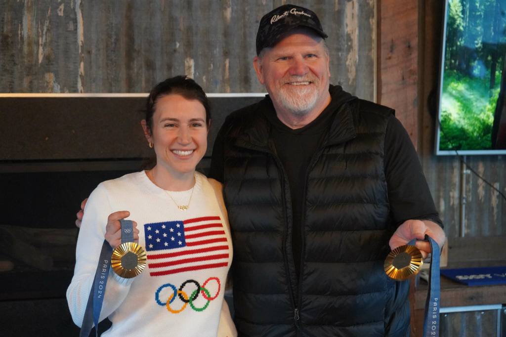 Kristen Faulkner, who won two gold medals for cycling at the Paris 2024 Olympics, stands for a photo with Ron Hyde during a meet and greet hosted by the Kenai and Soldotna chambers of commerce at the Cannery Lodge in Kenai, Alaska, on Saturday, Dec. 28, 2024. (Jake Dye/Peninsula Clarion)