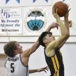 Cook Inlet Academys Matthew Phillips shoots against Ninilchiks Kade McCorison on Tuesday, Jan. 7, 2025, at Ninilchik School in Ninilchik, Alaska. (Photo by Jeff Helminiak/Peninsula Clarion)