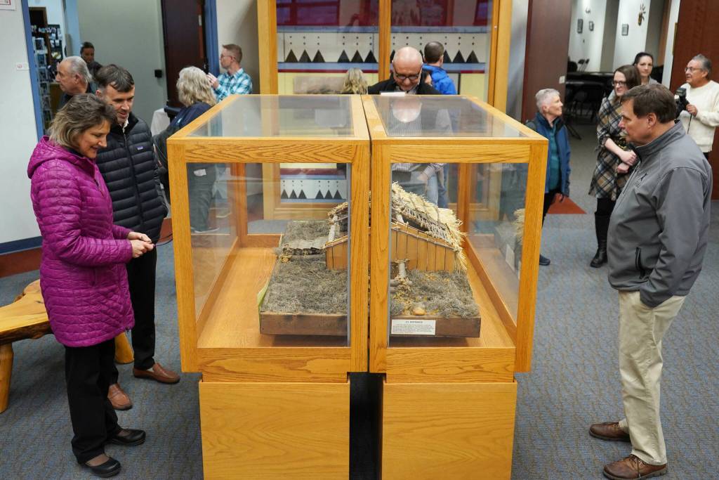 Attendees inspect a displayed model of a traditional Denaina home called a nichil during the grand reopening of the cultural center at the Kenai Chamber of Commerce and Visitor Center in Kenai, Alaska, on Wednesday, Jan. 15, 2025. (Jake Dye/Peninsula Clarion)