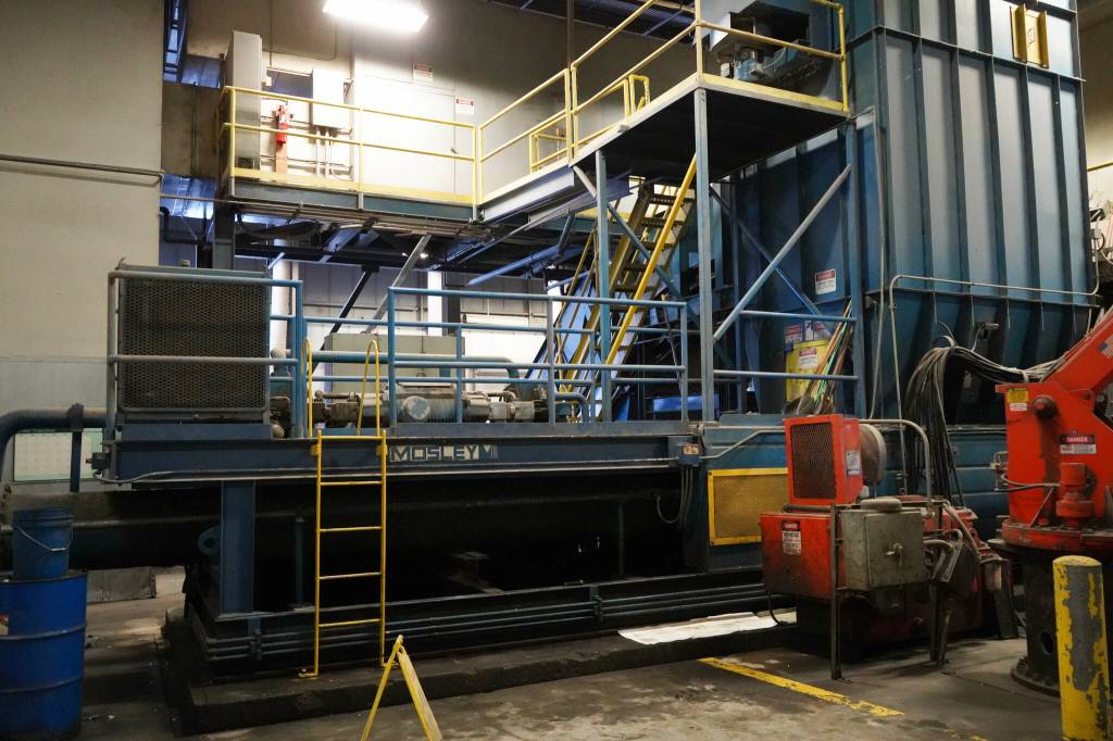 A large baler fills a building at the Central Peninsula Landfill in Soldotna, Alaska, on Thursday, Jan. 16, 2025. Before the ram attached to the bottom left was severed from the machine in a December failure, material was carried by a conveyor belt to the tower on the right and compressed into cubes. (Jake Dye/Peninsula Clarion)