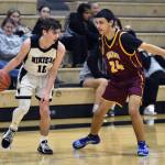 Nikiskis Carter Eiter dribbles against Dimond JVs Javier Meraz at the 36th Annual Rus Hitchcock Nikiski Tip Off Tournament on Thursday, Jan. 16, 2025, at Nikiski Middle-High School in Nikiski, Alaska. (Photo by Jeff Helminiak/Peninsula Clarion)
