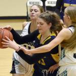 Ninilchiks Lucy Reynolds grabs the ball in front of Nikiskis Blakeley Jorgensen and Abby White at the 36th Annual Rus Hitchcock Nikiski Tip Off Tournament on Thursday, Jan. 16, 2025, at Nikiski Middle-High School in Nikiski, Alaska. (Photo by Jeff Helminiak/Peninsula Clarion)