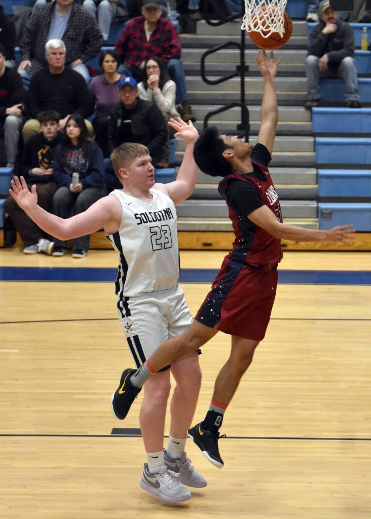 Jaidhen Oyao of Mountain City Christian Academy drives against Theo Huff of Soldotna on Friday, Jan. 17, 2025, at Soldotna High School in Soldotna, Alaska. (Photo by Jeff Helminiak/Peninsula Clarion)