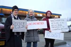 Diane Peterson, Casady Herding and Jen Brighton stand with signs sharing Martin Luther King Jr. quotes are calling to Resist along the side of the Kenai Spur Highway in Soldotna, Alaska, on Monday, Jan. 20, 2025. (Jake Dye/Peninsula Clarion)