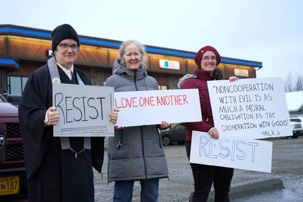 Diane Peterson, Casady Herding and Jen Brighton stand with signs sharing Martin Luther King Jr. quotes are calling to "Resist" along the side of the Kenai Spur Highway in Soldotna, Alaska, on Monday, Jan. 20, 2025. (Jake Dye/Peninsula Clarion)