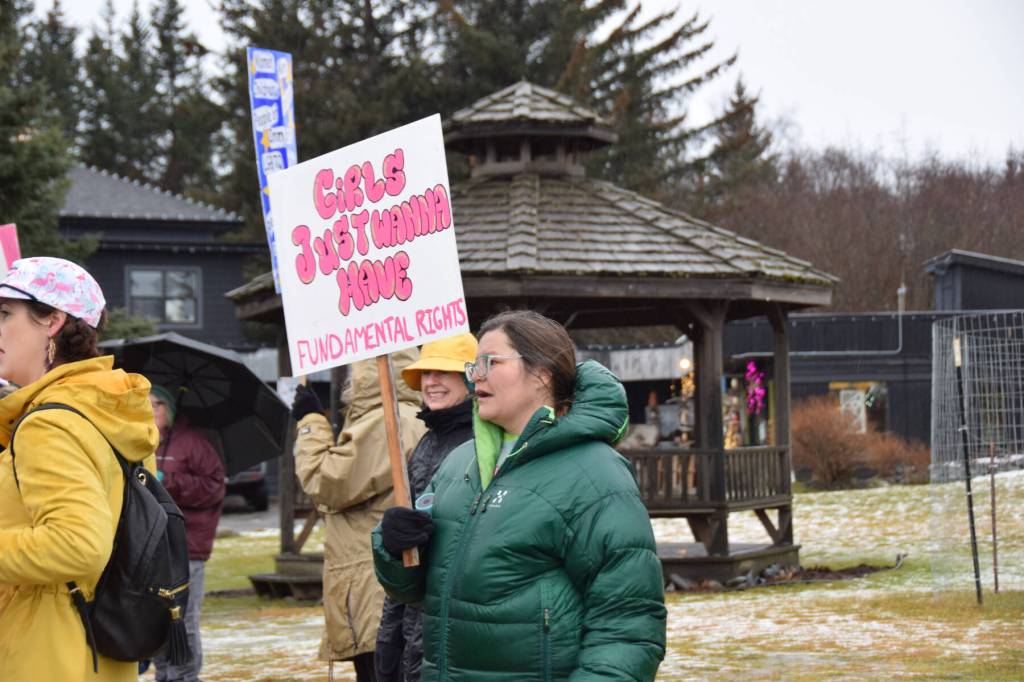 A woman carrying a sign that says Girls Just Wanna Have Fundamental Rights gathers with other marchers at WKFL Park in Homer, Alaska, at the conclusion of the Homer Womens March on Saturday, Jan. 18, 2025. (Delcenia Cosman/Homer News)