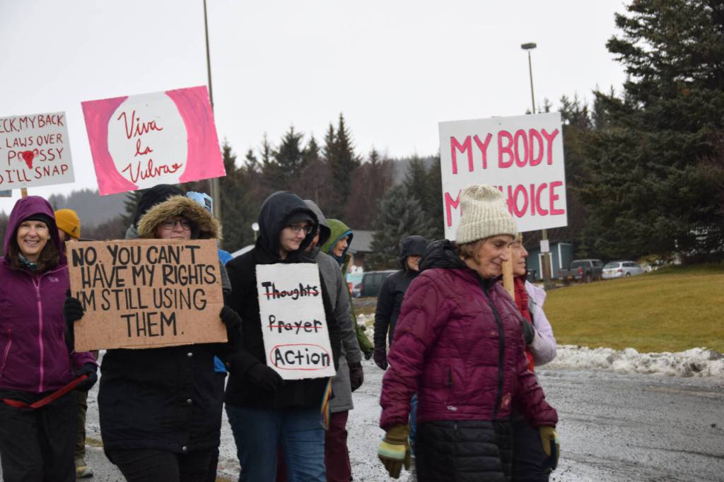 Marchers carry signs in the Homer Womens March on Saturday, Jan. 18, 2025, on Pioneer Avenue in Homer, Alaska. (Delcenia Cosman/Homer News)
