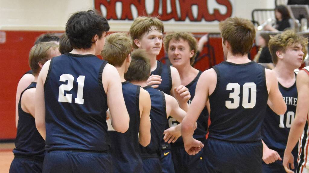 The Homer Mariners celebrate a game-winning shot by Henry Wedvik (front and center) Tuesday, Jan. 21, 2025, at Kenai Central High School in Kenai, Alaska. (Photo by Jeff Helminiak/Peninsula Clarion)