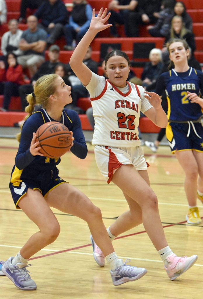 Homers Emily Stafford drives on Kenai Centrals Bryleigh Williams on Tuesday, Jan. 21, 2025, at Kenai Central High School in Kenai, Alaska. (Photo by Jeff Helminiak/Peninsula Clarion)
