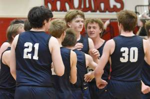 The Homer Mariners celebrate a game-winning shot by Henry Wedvik (front and center) Tuesday, Jan. 21, 2025, at Kenai Central High School in Kenai, Alaska. (Photo by Jeff Helminiak/Peninsula Clarion)