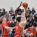 Soldotnas Damari Adams drives on Kenai Centrals Eli Smith, Miles Metteer and Ben Smith on Friday, Jan. 24, 2025, at the Revolution Sport and Spine Therapy Al Howard Shootout at Soldotna High School in Soldotna, Alaska. (Photo by Jeff Helminiak/Peninsula Clarion)