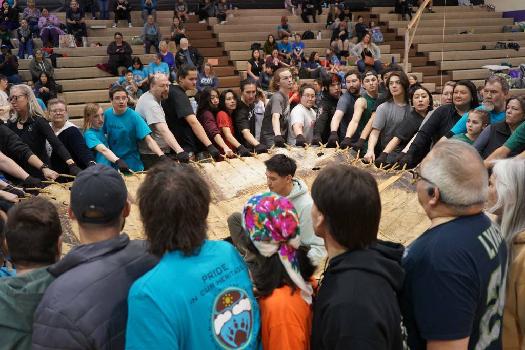 More than 50 people work together to perform a traditional blanket toss during the Kahtnuhtana Hey Chiula Native Youth Olympics Invitational at Skyview Middle School near Soldotna, Alaska, on Sunday, Jan. 26, 2025. (Jake Dye/Peninsula Clarion)