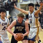 Nikiskis Kameron Bird attacks the defense of Matthew Phillips and Lucas Oyoumick of Cook Inlet Academy on Tuesday, Jan. 28, 2025, at Cook Inlet Academy just outside of Soldotna, Alaska. (Photo by Jeff Helminiak/Peninsula Clarion)