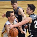 Owen Braband of Cook Inlet Academy faces pressure from Kaleb Allen and Ryder Maguire of Nikiski on Tuesday, Jan. 28, 2025, at Cook Inlet Academy just outside of Soldotna, Alaska. (Photo by Jeff Helminiak/Peninsula Clarion)