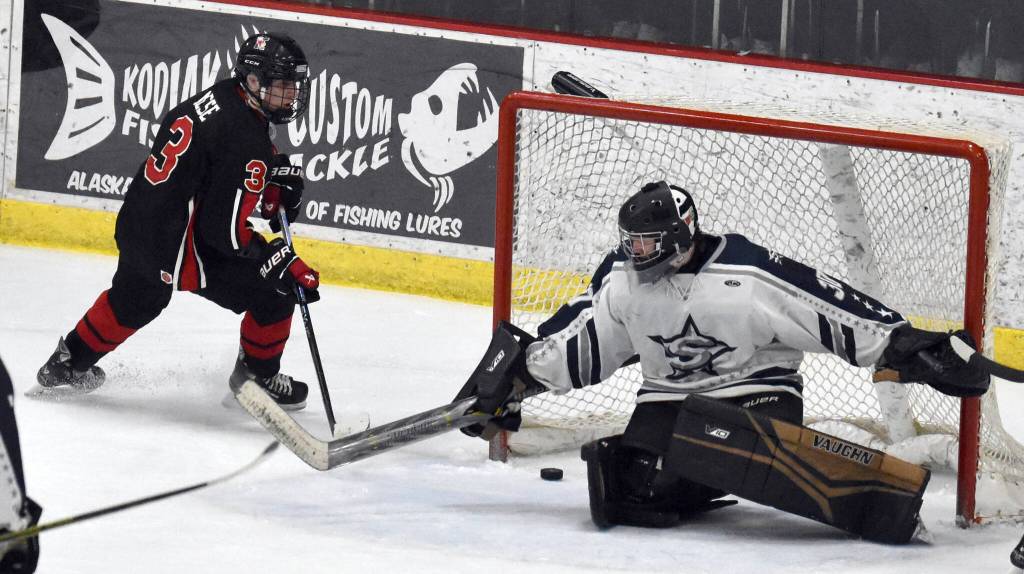 Kenai Centrals Logan Mese scores the game-winner in overtime against Soldotna goalie Brycen Clyde on Thursday, Jan. 30, 2025, at the Soldotna Regional Sports Complex in Soldotna, Alaska. (Photo by Jeff Helminiak/Peninsula Clarion)