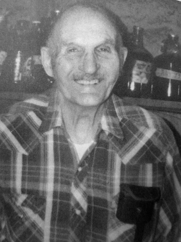 Photo from In Those Days: Alaska Pioneers of the Lower Kenai Peninsula, Vol. II
Poopdeck Platt smiles for the camera in his well-stocked Homer cellar of homemade wines.