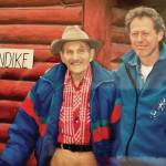 Bob Kanegis (right) poses with Clarence Hiram Poopdeck Platt in front of Platts cabin near the center of Homer, circa late 1990s. (Photo courtesy of Bob Kanegis)