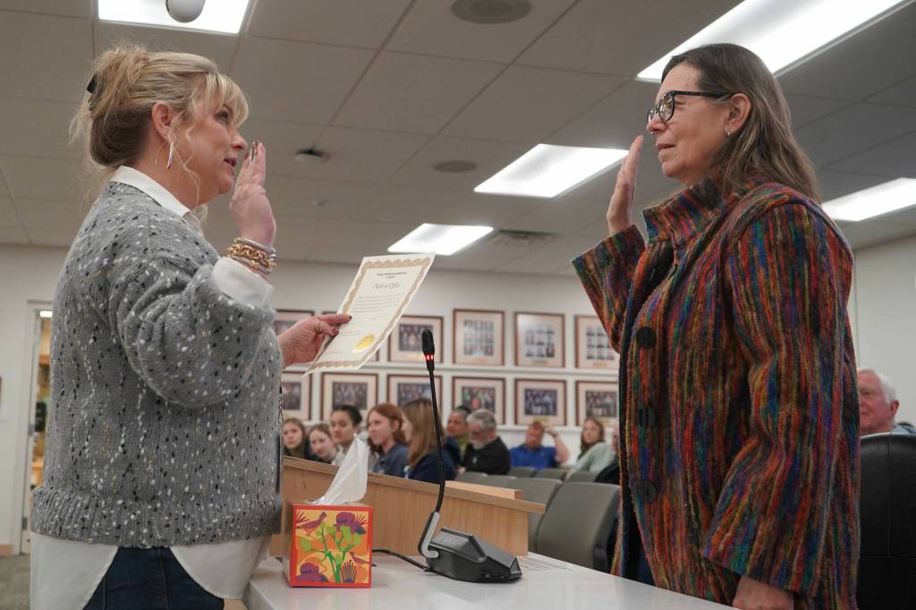 Borough Clerk Michele Turner administers an oath of office to Leslie Morton after Morton was appointed as the new Kenai Peninsula Borough Assembly representative for Sterling and Funny River during an assembly meeting in Soldotna, Alaska, on Tuesday, Feb. 4, 2025. (Jake Dye/Peninsula Clarion)