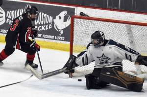 Kenai Central's Logan Mese scores the game-winner in overtime against Soldotna goalie Brycen Clyde on Thursday, Jan. 30, 2025, at the Soldotna Regional Sports Complex in Soldotna, Alaska. (Photo by Jeff Helminiak/Peninsula Clarion)