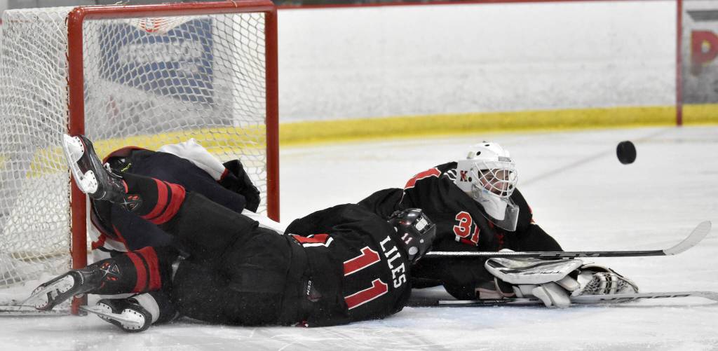 Kenai Centrals Evyn Witt makes a save in front of teammate Gavin Liles against North Pole at the First National Cup Division II state hockey tournament at the Soldotna Regional Sports Complex in Soldotna, Alaska, on Thursday, February 6, 2025. (Photo by Jeff Helminiak/Peninsula Clarion)
