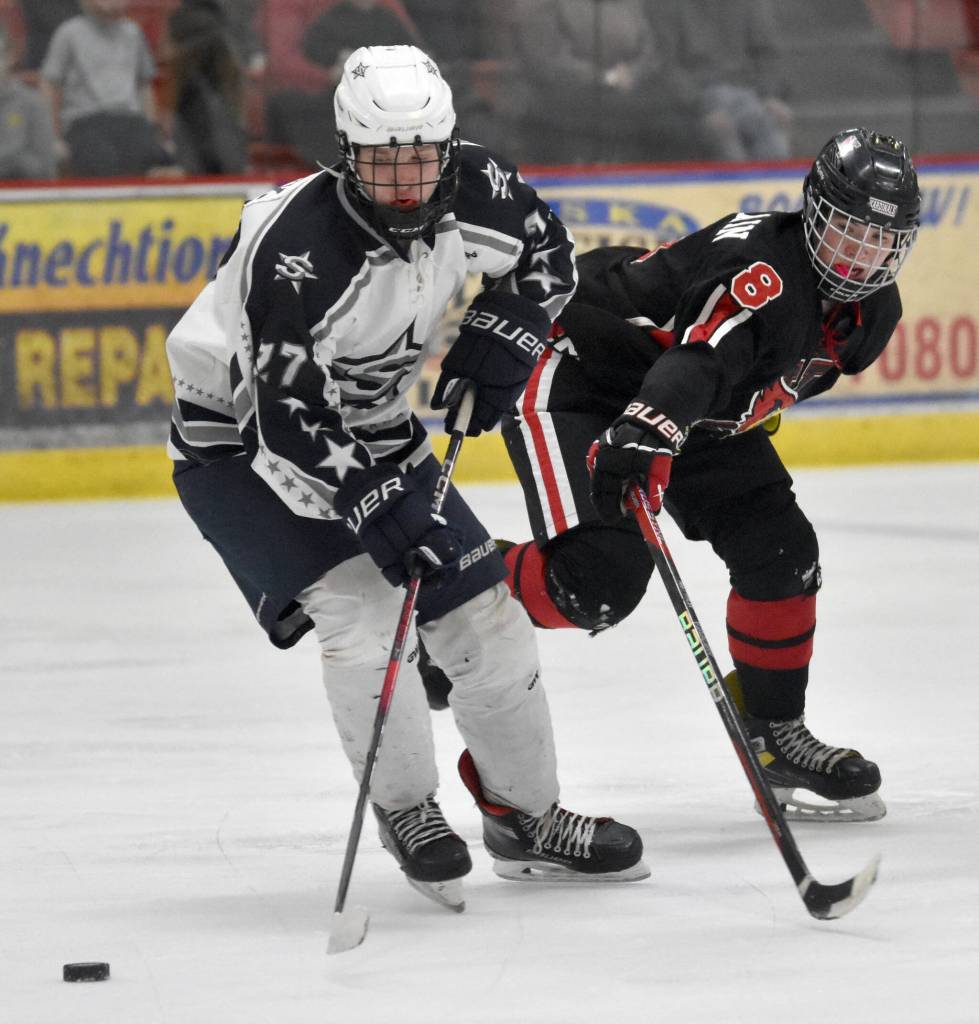 Soldotnas Keegan Myrick shields the puck from Kenai Centrals Everett Chamberlain on Friday, Feb. 7, 2025, at the First National Cup Division II state hockey tournament at the Soldotna Regional Sports Complex in Soldotna, Alaska. (Photo by Jeff Helminiak/Peninsula Clarion)
