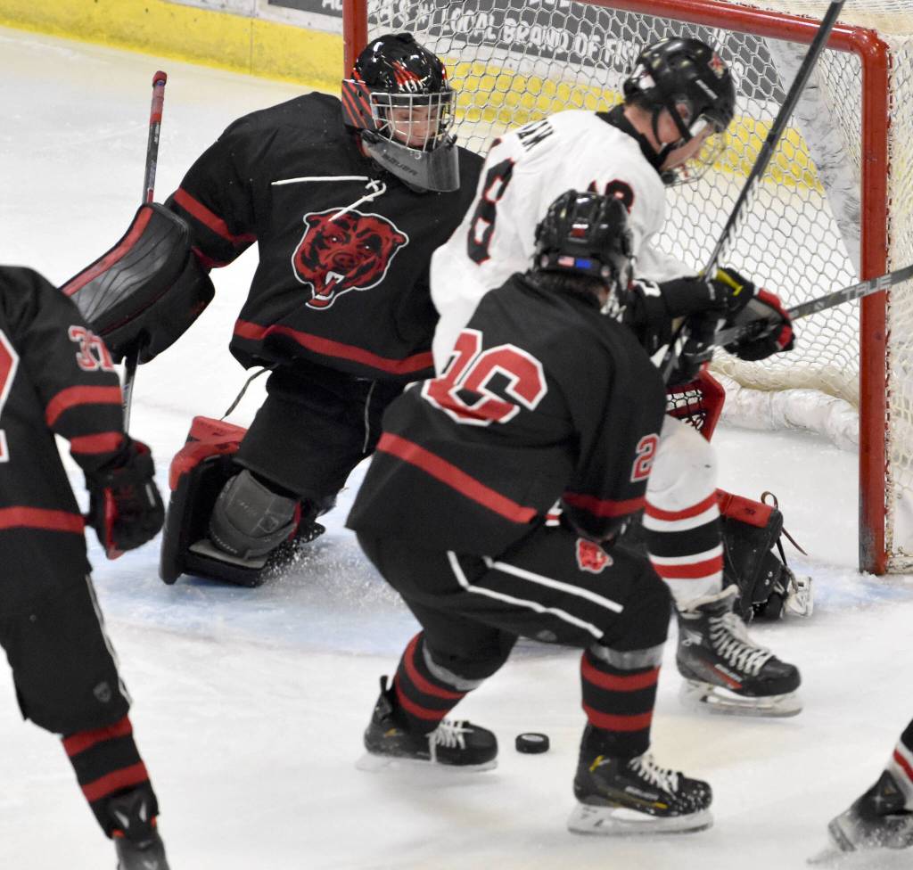 Kenai Centrals Sawyer Vann and Elliot Welch of Juneau-Douglas battle for the puck in front of Juneau goalie Caleb Friend at the First National Cup Division II state hockey tournament Saturday, February 8, 2025, at the Soldotna Regional Sports Complex in Soldotna, Alaska. (Photo by Jeff Helminiak/Peninsula Clarion)