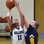 Nikiskis Blakeley Jorgensen is fouled by Homers Keagan Niebuhr on Tuesday, February 11, 2025, at Nikiski Middle-High School in Nikiski, Alaska. (Photo by Jeff Helminiak/Peninsula Clarion)