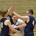 Nikiskis Lynn Deveer drives on Homers Henry Wedvik and Einar Pederson on Tuesday, February 11, 2025, at Nikiski Middle-High School in Nikiski, Alaska. (Photo by Jeff Helminiak/Peninsula Clarion)