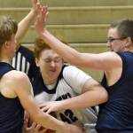 Nikiski's Lynn Deveer drives on Homer's Henry Wedvik and Einar Pederson on Tuesday, February 11, 2025, at Nikiski Middle-High School in Nikiski, Alaska. (Photo by Jeff Helminiak/Peninsula Clarion)