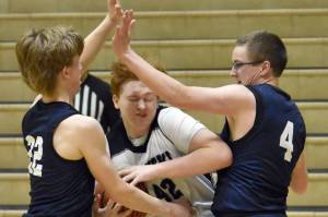 Nikiski's Lynn Deveer drives on Homer's Henry Wedvik and Einar Pederson on Tuesday, February 11, 2025, at Nikiski Middle-High School in Nikiski, Alaska. (Photo by Jeff Helminiak/Peninsula Clarion)