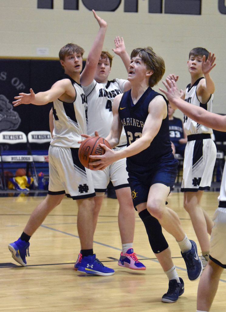 Homers Henry Wedvik drives on Nikiski on Tuesday, February 11, 2025, at Nikiski Middle-High School in Nikiski, Alaska. (Photo by Jeff Helminiak/Peninsula Clarion)