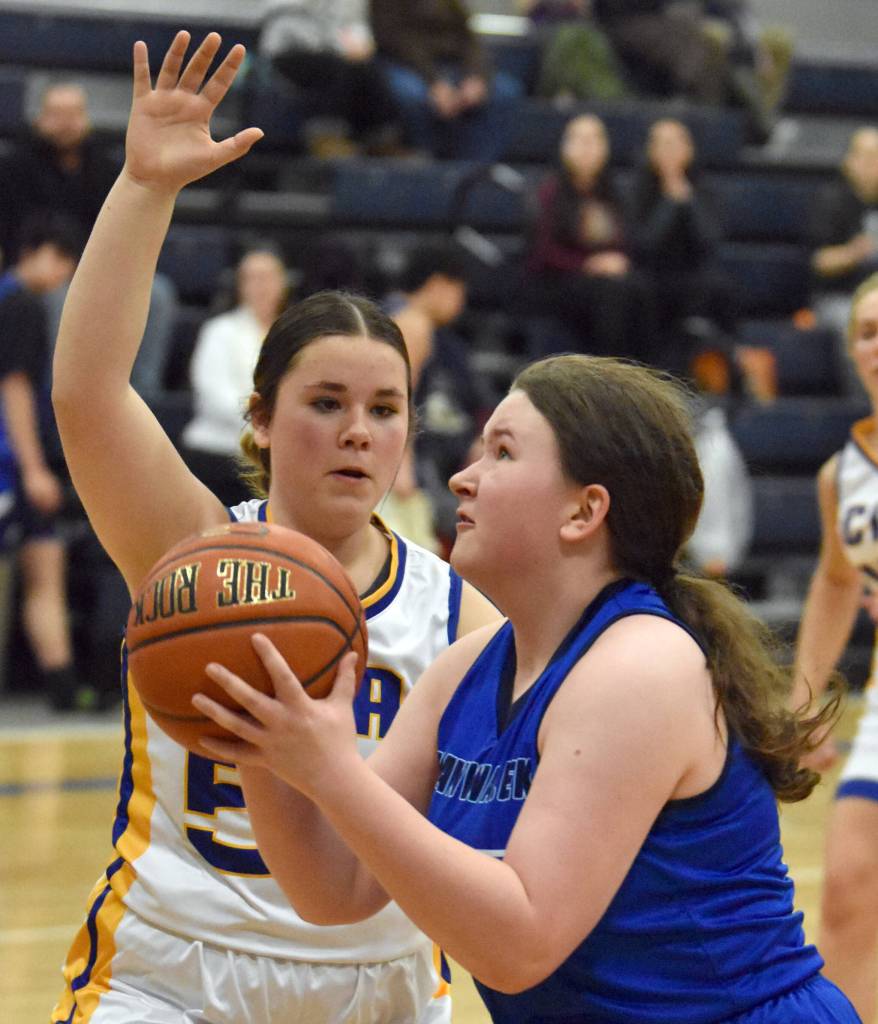 Hadassah Haskins of Nanwalek drives on Maria Smith of Cook Inlet Academy on Saturday, February 15, 2025, at Cook Inlet Academy just outside of Soldotna, Alaska. (Photo by Jeff Helminiak/Peninsula Clarion)