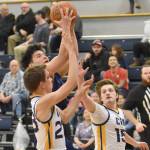 Nanwaleks Sean Moonin drives on Owen Braband and Blaine Hunt on Saturday, February 15, 2025, at Cook Inlet Academy just outside of Soldotna, Alaska. (Photo by Jeff Helminiak/Peninsula Clarion)