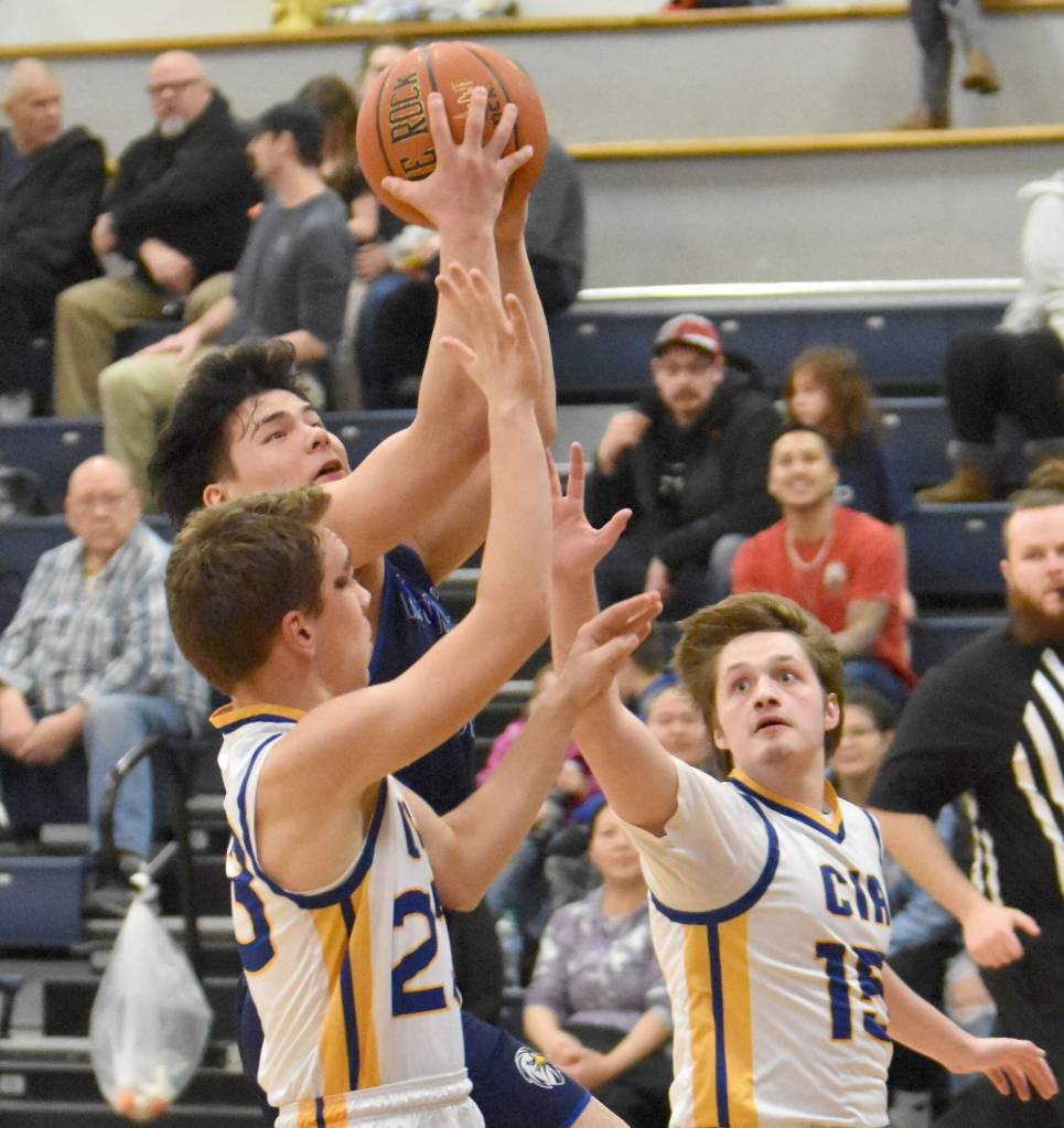 Nanwaleks Sean Moonin drives on Owen Braband and Blaine Hunt on Saturday, February 15, 2025, at Cook Inlet Academy just outside of Soldotna, Alaska. (Photo by Jeff Helminiak/Peninsula Clarion)