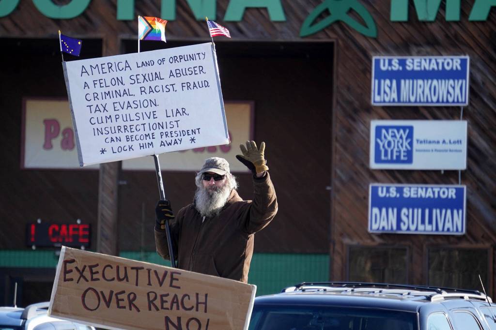 Gary Todd stands among protesters with signs in support of federal employees, federal lands and the U.S. Constitution stand along the Sterling Highway in Soldotna, Alaska, on Monday, Feb. 17, 2025. (Jake Dye/Peninsula Clarion)