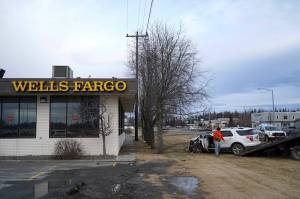 A 2015 Ford Explorer that was stolen from the Kenai Chamber of Commerce before crashing into a tree near Wells Fargo Bank is loaded onto a tow truck in Kenai, Alaska, on Tuesday, Feb. 18, 2025. (Jake Dye/Peninsula Clarion)