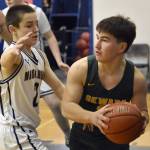 Sewards Noah Price protects the ball from Ninilchiks Eric Rader on Friday, February 21, 2025, at Ninilchik School in Ninilchik, Alaska. (Photo by Jeff Helminiak/Peninsula Clarion)