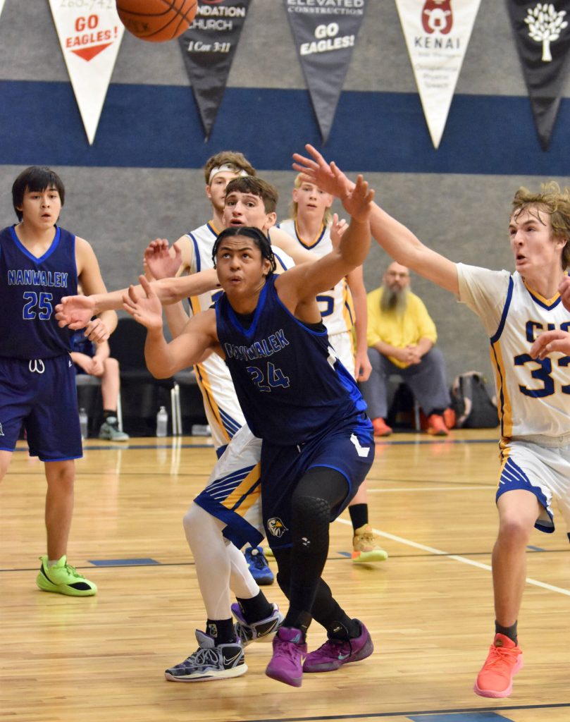Nanwaleks Marcarius Evans battles with Cook Inlet Academys Alek McGarry and Brandt Rollman on Saturday, March 1, 2025, at the Peninsula Conference tournament at Cook Inlet Academy just outside of Soldotna, Alaska. (Photo by Jeff Helminiak/Peninsula Clarion)