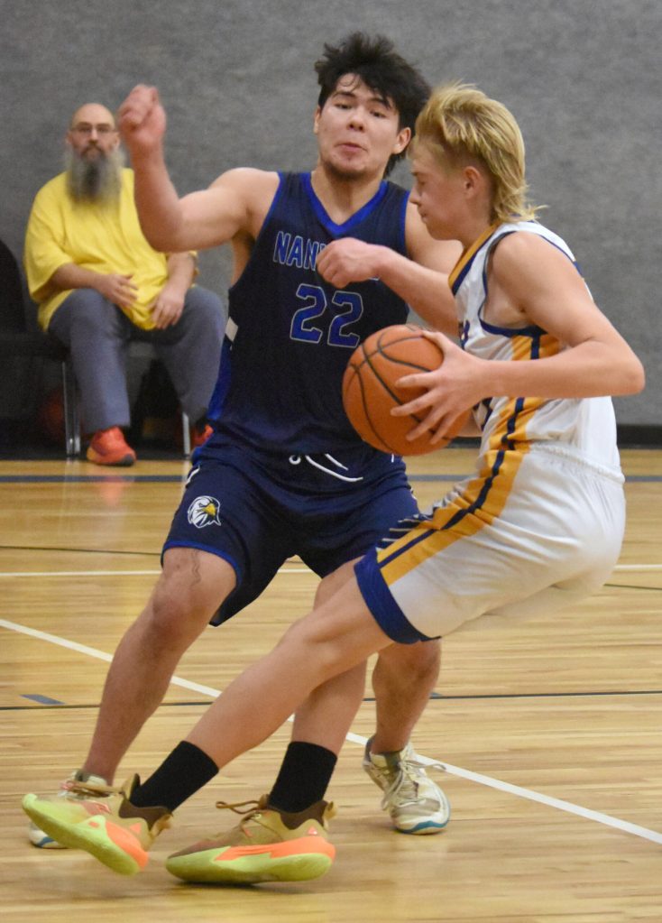 Cook Inlet Academys Hyrum Henderson drives on Nanwaleks Sean Moonin on Saturday, March 1, 2025, at the Peninsula Conference tournament at Cook Inlet Academy just outside of Soldotna, Alaska. (Photo by Jeff Helminiak/Peninsula Clarion)