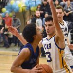 Nanwaleks Kenji Simmons drives on Cook Inlet Academys Ian McGarry on Saturday, March 1, 2025, at the Peninsula Conference tournament at Cook Inlet Academy just outside of Soldotna, Alaska. (Photo by Jeff Helminiak/Peninsula Clarion)