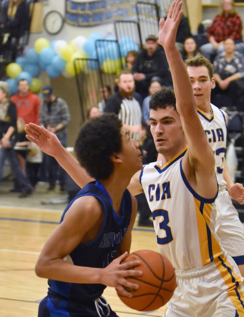Nanwaleks Kenji Simmons drives on Cook Inlet Academys Ian McGarry on Saturday, March 1, 2025, at the Peninsula Conference tournament at Cook Inlet Academy just outside of Soldotna, Alaska. (Photo by Jeff Helminiak/Peninsula Clarion)